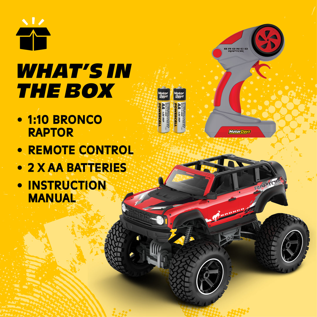 Toy truck with remote control, batteries, and instruction manual on a yellow background