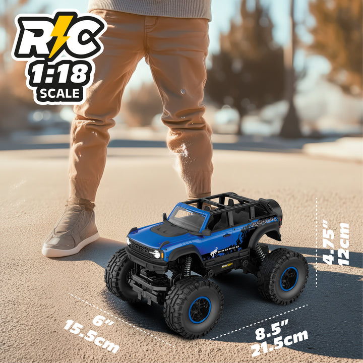 Blue and black RC toy truck on a road with a person for scale, featuring 'RC 1:18 Scale' text.