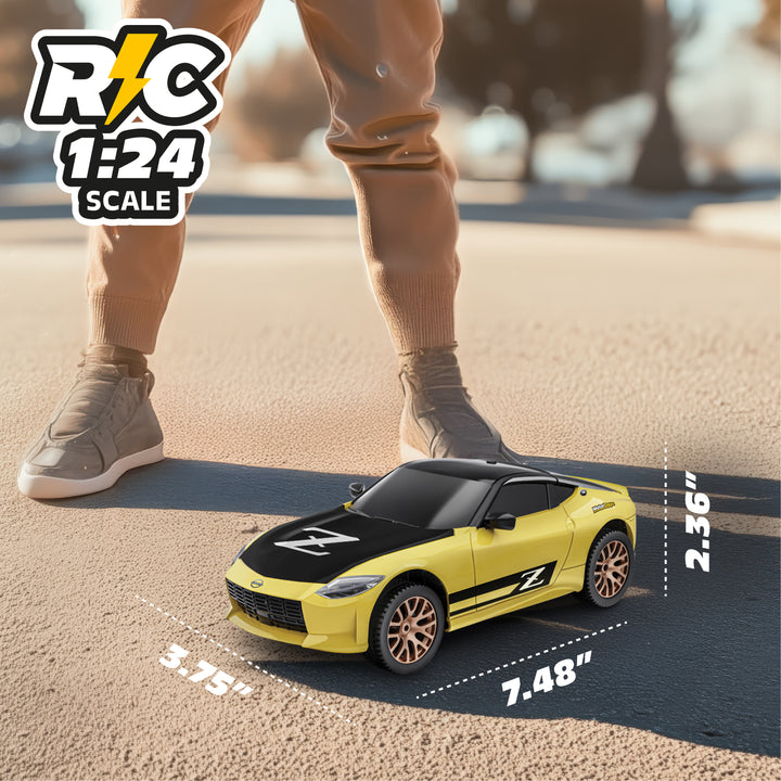 Yellow RC car on a road with a person's legs and feet in the background, showing scale dimensions.